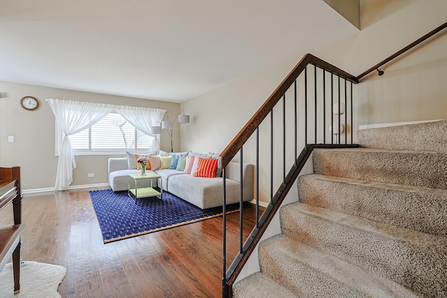 staircase with baseboards and wood finished floors