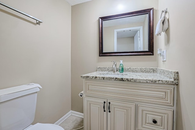 half bath featuring vanity, baseboards, and toilet