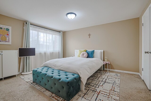 bedroom featuring baseboards and carpet