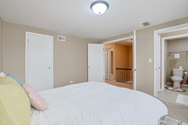 bedroom featuring visible vents, baseboards, and ensuite bathroom