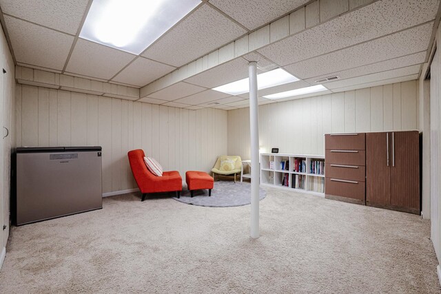 sitting room featuring carpet floors, visible vents, and a paneled ceiling