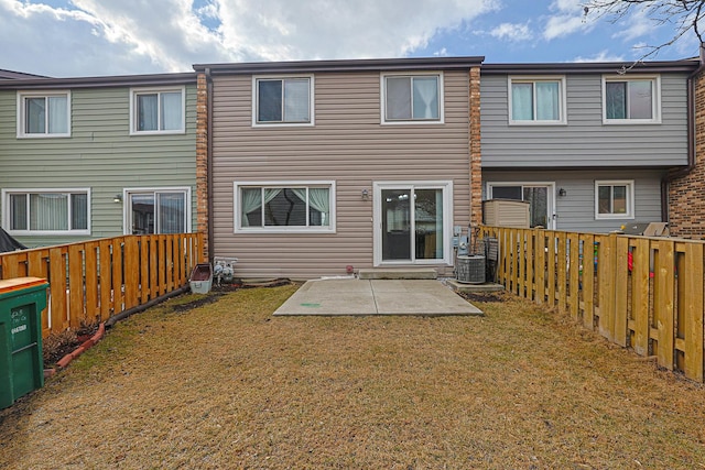 back of house with a fenced backyard, a patio area, central AC, and a yard