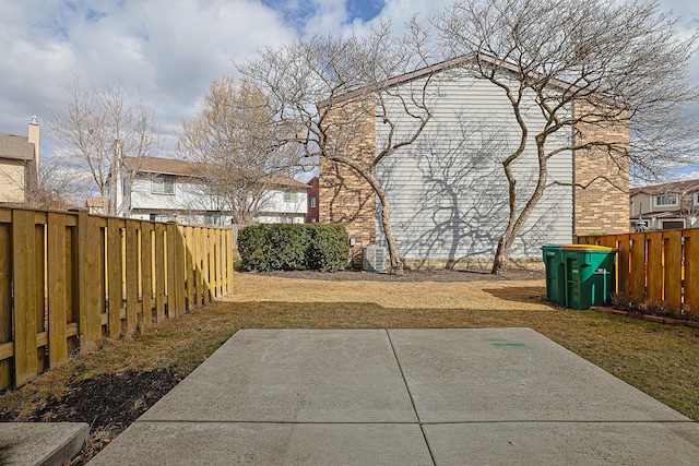 view of yard with a fenced backyard, a patio, and central AC
