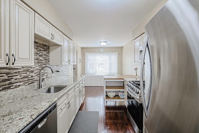 kitchen with a sink, stainless steel appliances, white cabinetry, tasteful backsplash, and dark wood-type flooring