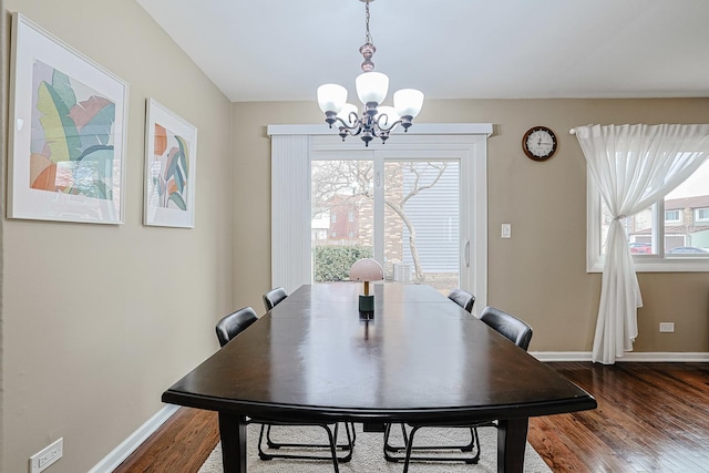 dining area featuring an inviting chandelier, baseboards, and dark wood-style flooring
