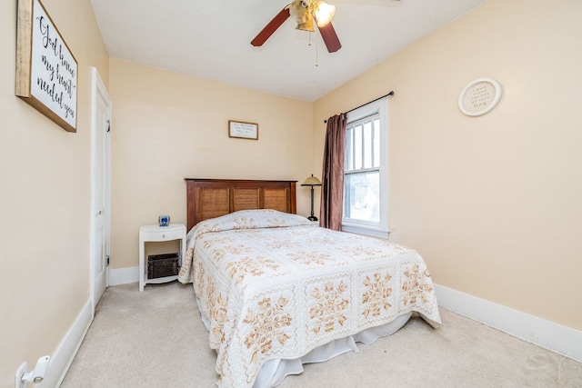 bedroom featuring light colored carpet, baseboards, and ceiling fan