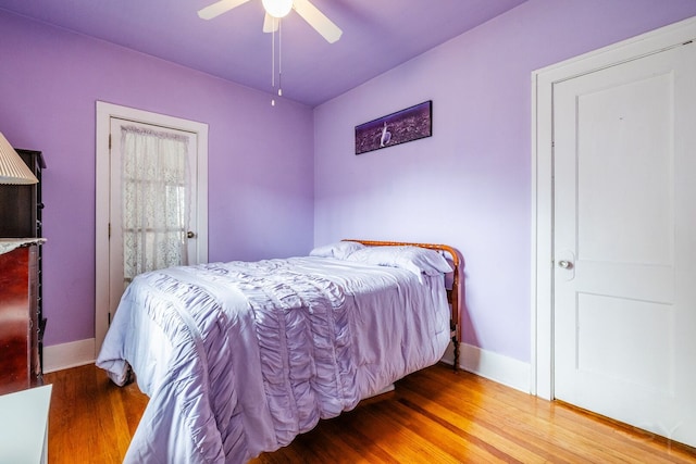 bedroom with wood finished floors, baseboards, and ceiling fan