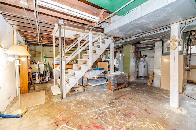unfinished basement with water heater, gas water heater, and stairway