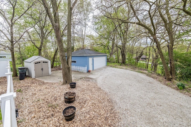 view of yard featuring an outdoor structure, a garage, and fence