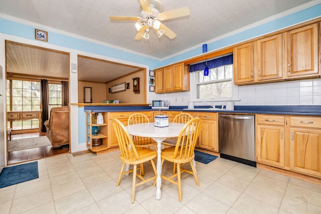 kitchen with stainless steel appliances, dark countertops, crown molding, a ceiling fan, and tasteful backsplash