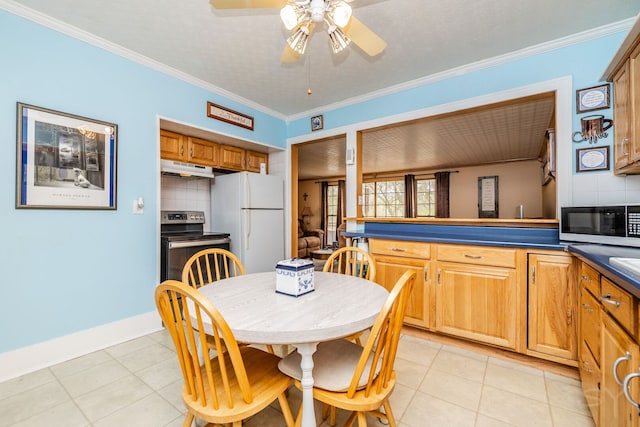 kitchen featuring freestanding refrigerator, backsplash, under cabinet range hood, a ceiling fan, and dark countertops
