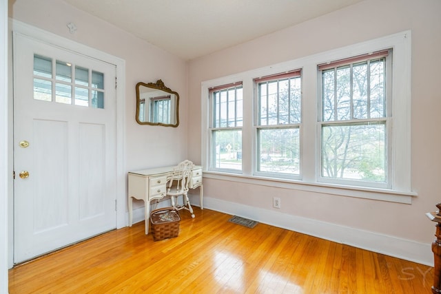 doorway with baseboards and wood finished floors