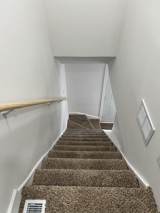 stairway with baseboards, carpet, and visible vents