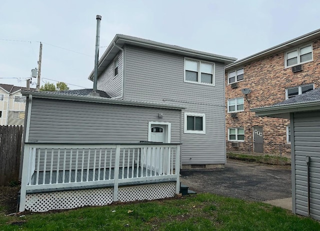 rear view of house with fence and a deck
