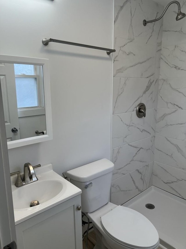 bathroom featuring toilet, a shower stall, and vanity