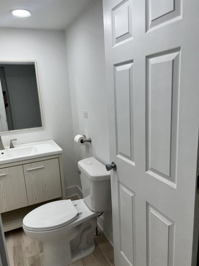half bathroom with vanity and toilet
