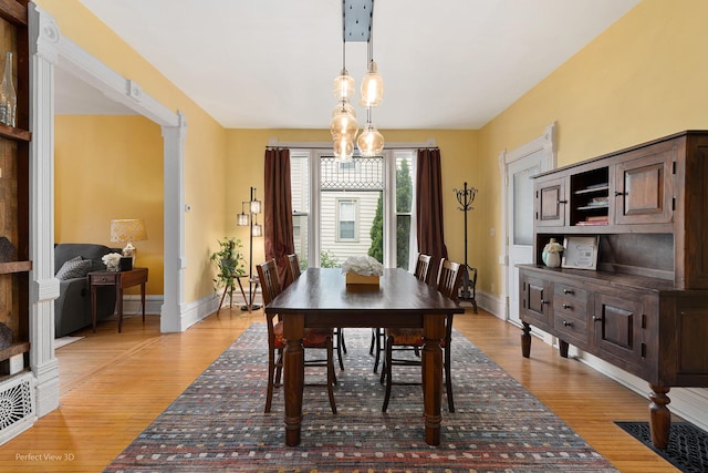 dining area featuring baseboards and light wood-style flooring