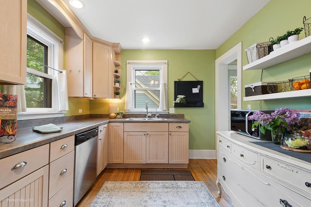 kitchen featuring open shelves, stainless steel dishwasher, light wood-style flooring, and a sink