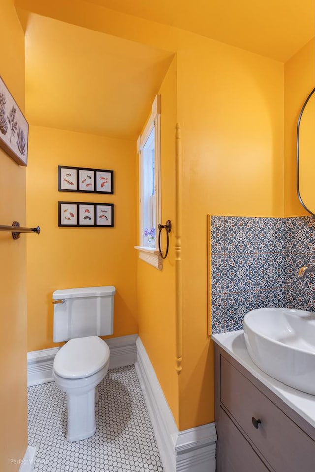 bathroom with vanity, toilet, baseboards, and tile patterned floors