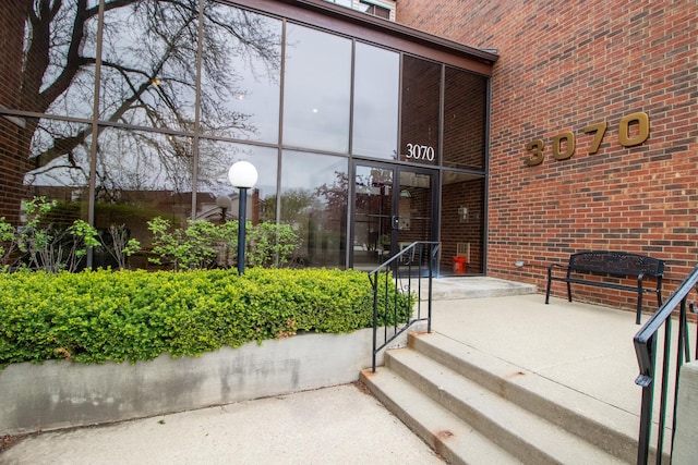 entrance to property featuring brick siding