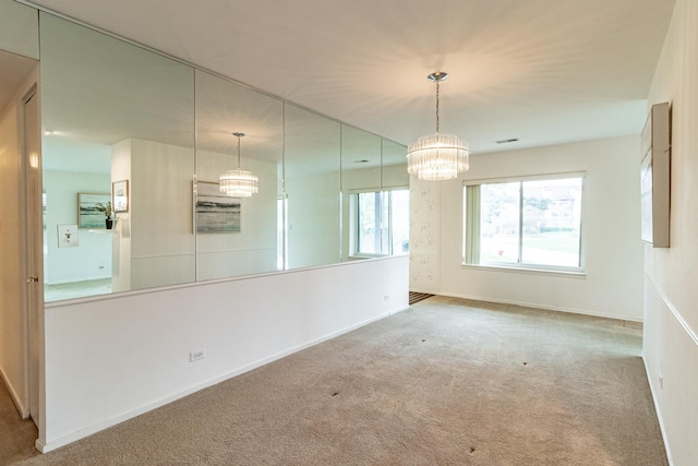 unfurnished dining area featuring baseboards, carpet, a chandelier, and visible vents