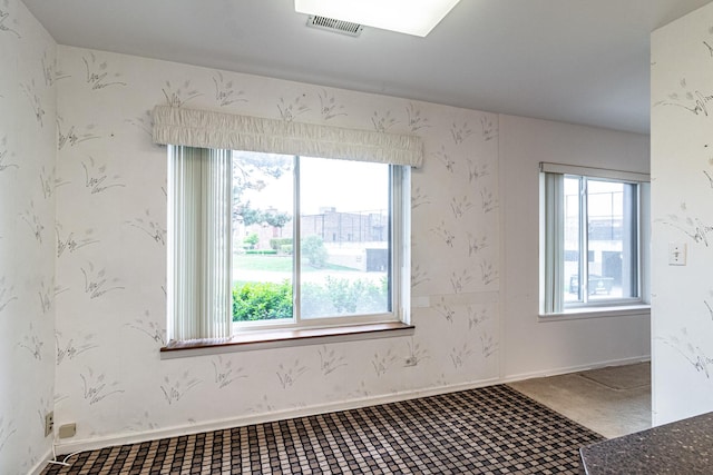 unfurnished room with visible vents and baseboards