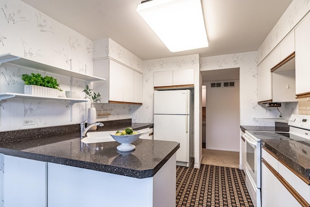 kitchen featuring open shelves, decorative backsplash, a peninsula, white appliances, and white cabinetry