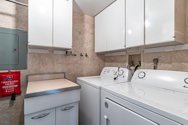 laundry area with cabinet space, independent washer and dryer, and electric panel