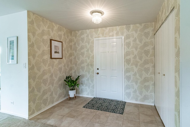 foyer entrance featuring baseboards and light tile patterned flooring