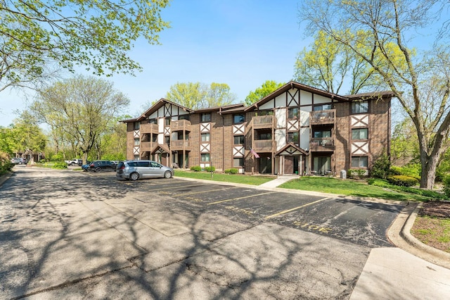 view of apartment building / complex featuring uncovered parking