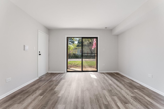 unfurnished room with wood finished floors and baseboards