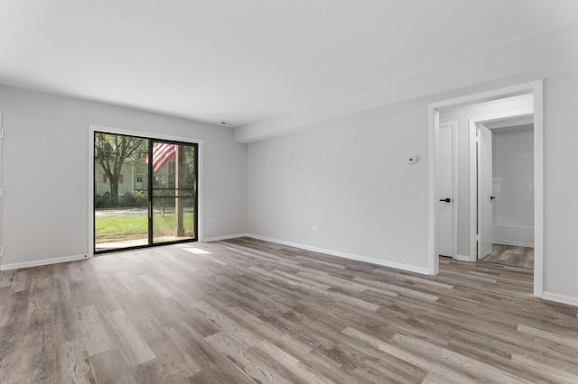 unfurnished room with wood finished floors and baseboards