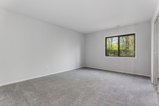unfurnished room featuring carpet flooring and baseboards
