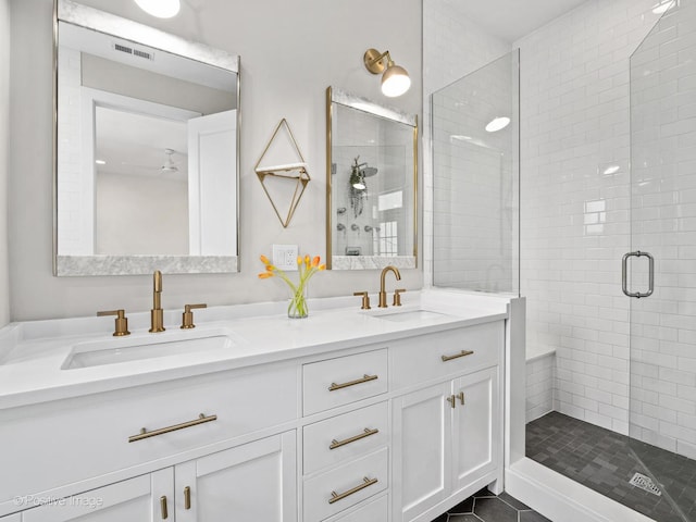bathroom featuring a shower stall, double vanity, ceiling fan, and tile patterned flooring