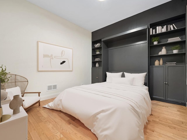 bedroom with light wood-style flooring and baseboards