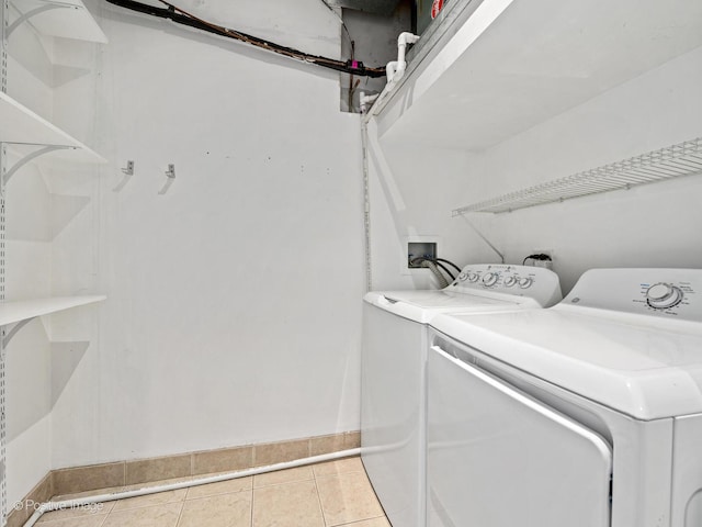 laundry room featuring washer and dryer, tile patterned floors, and baseboards