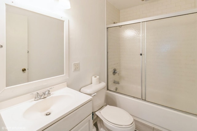 full bath featuring toilet, shower / bath combination with glass door, and vanity