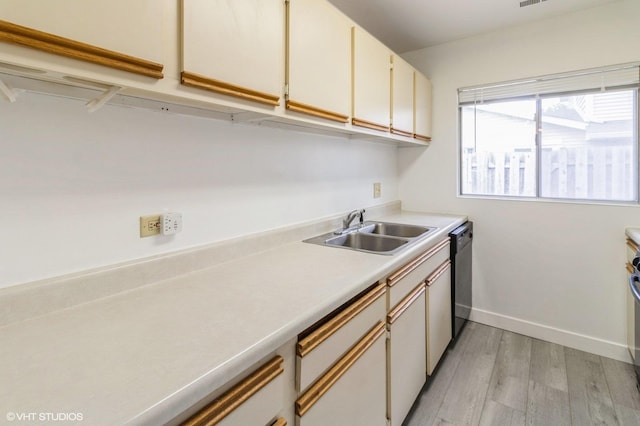 washroom with a sink, light wood-style flooring, and baseboards