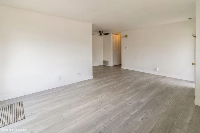 empty room featuring ceiling fan, wood finished floors, and baseboards
