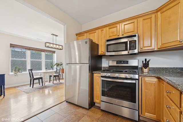 kitchen with a notable chandelier, baseboards, dark stone counters, and appliances with stainless steel finishes