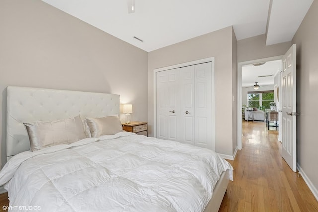 bedroom with baseboards, light wood finished floors, and a closet