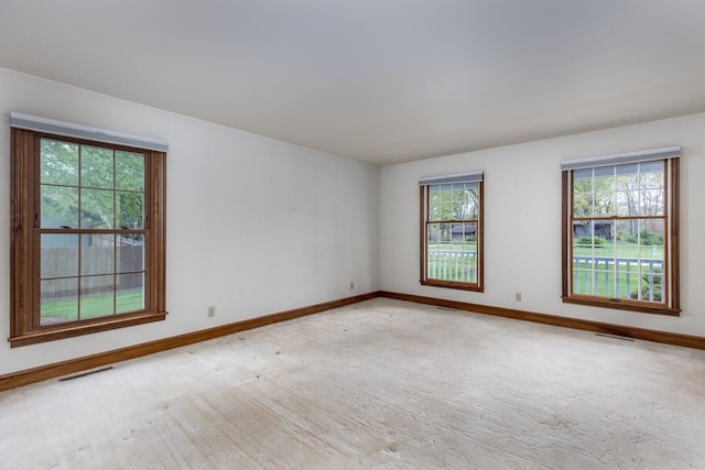 carpeted empty room with visible vents and baseboards