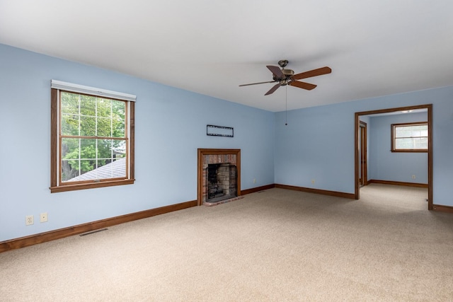 unfurnished living room featuring carpet, baseboards, visible vents, and plenty of natural light