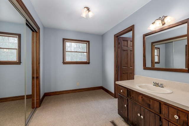 bathroom featuring vanity, carpet flooring, baseboards, and visible vents