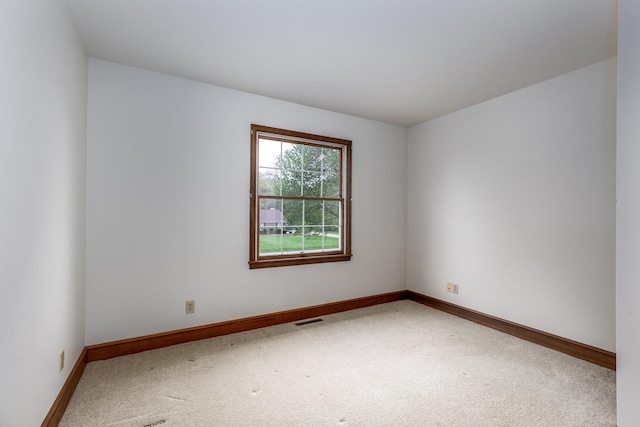 spare room with visible vents, baseboards, and carpet floors