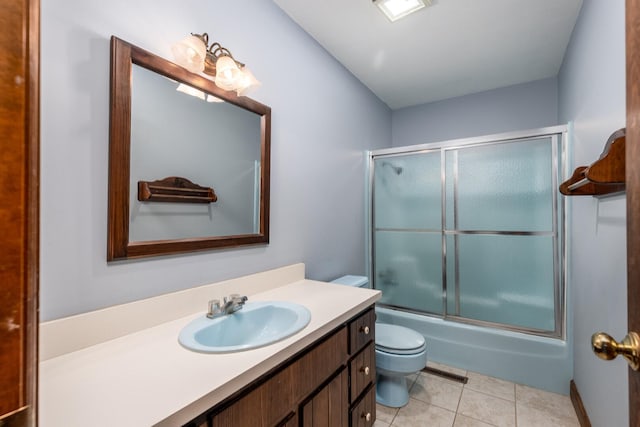 bathroom with toilet, visible vents, shower / bath combination with glass door, tile patterned floors, and vanity