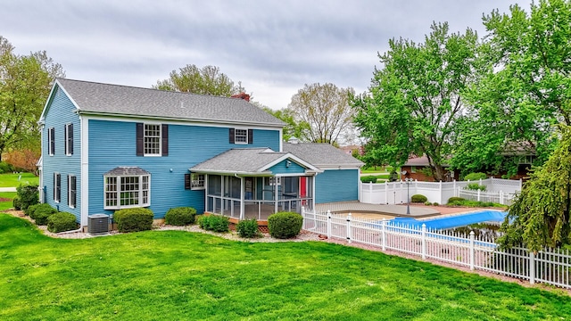 back of house with central AC, a fenced backyard, a fenced in pool, a lawn, and a sunroom