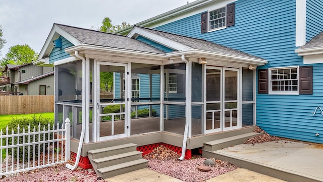 exterior space featuring a shingled roof and fence