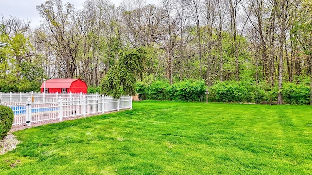 view of yard featuring an outdoor structure, fence, and a fenced in pool