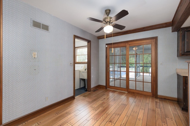 entryway featuring light wood finished floors, wallpapered walls, baseboards, and a ceiling fan